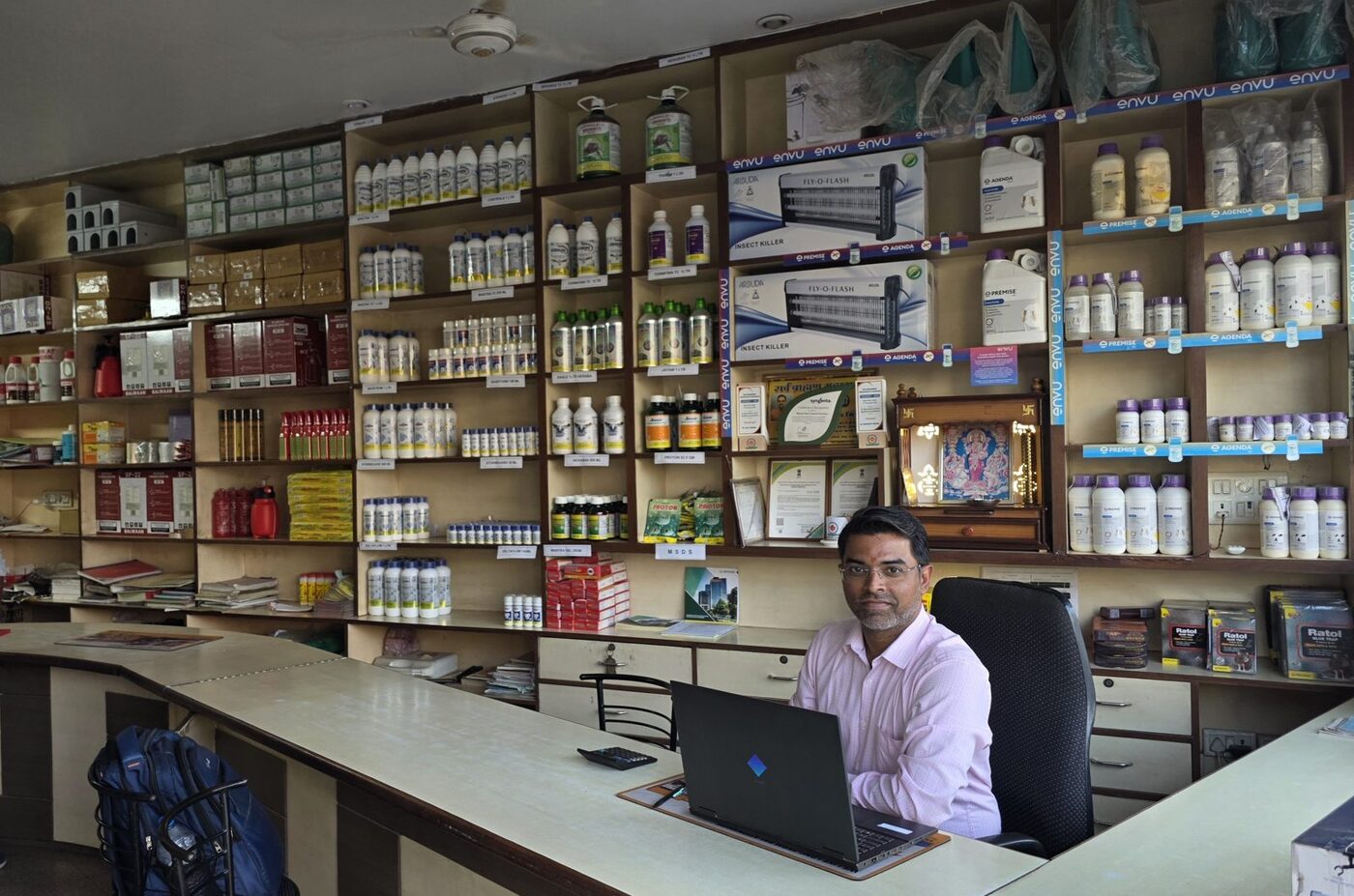 Bharat Pest Control Services team member at the Jaipur showroom desk with ENVU Premise, Agenda and Syngenta product shelves